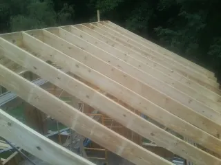 New roof rafters set over an addition before sheathing in Hadley